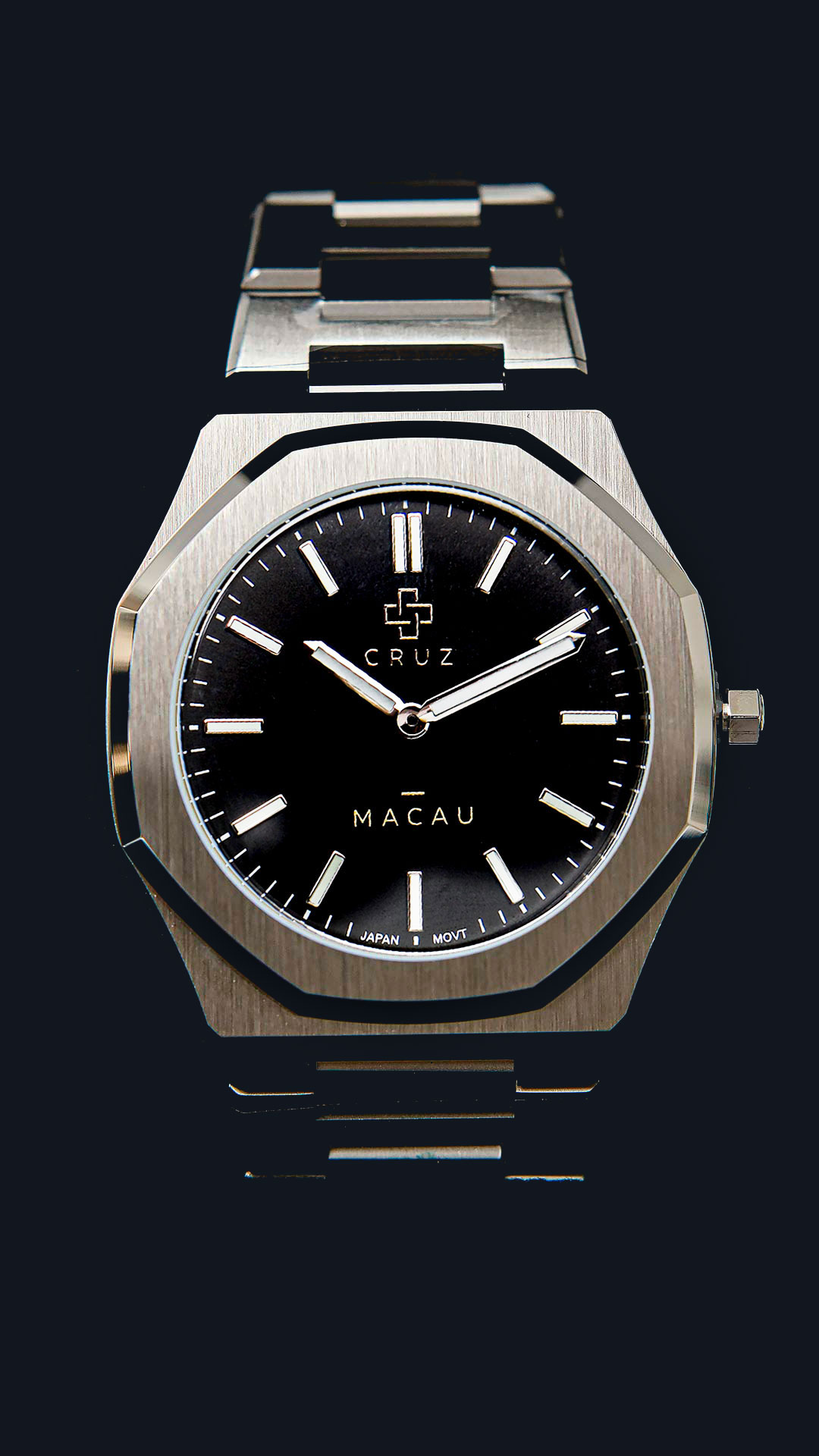 Cruz Watches Macau com mostrador preto, caixa prateada e pulseira de aço, sobre fundo escuro.